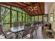 Inviting sunroom with screened windows, ceiling fan, and woodland view at 480 Springs End Ne Ln, Marietta, GA 30068