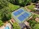 Aerial view showcasing tennis courts with lighting, surrounded by trees and lush landscape at 480 Springs End Ne Ln, Marietta, GA 30068