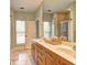Bathroom with a dual sink vanity, tile floors, and a large mirror reflecting a tiled shower at 5883 Brookside Oak Cir, Norcross, GA 30093