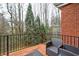 Exterior view of a wood deck with black metal railings and outdoor furniture with a wooded view at 5883 Brookside Oak Cir, Norcross, GA 30093