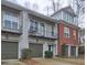 Exterior side view of light gray brick townhouses and a brick building with attached garages at 5883 Brookside Oak Cir, Norcross, GA 30093
