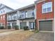 A row of townhouses featuring light gray brick and balconies with attached single-car garages at 5883 Brookside Oak Cir, Norcross, GA 30093