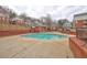 Community pool surrounded by brick walls with a gate and townhomes in the background at 5883 Brookside Oak Cir, Norcross, GA 30093