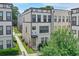 A modern two-story townhome featuring neutral siding, a brick accent wall, and manicured landscaping at 2032 Holtz Ln, Atlanta, GA 30318