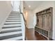 Hallway with hardwood floors, white trim, coat rack, and adjacent staircase at 2032 Holtz Ln, Atlanta, GA 30318