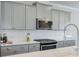 Modern kitchen with white subway tile backsplash, stainless steel appliances and gray cabinets at 2032 Holtz Ln, Atlanta, GA 30318