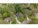 Aerial perspective of a home nestled among mature trees, featuring a long driveway and lush landscaping in a quiet neighborhood at 11165 Bentley Chase Dr, Johns Creek, GA 30097