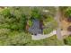 An aerial view reveals a beautiful home with a dark roof and well-manicured landscaping amidst a lush, green environment at 11165 Bentley Chase Dr, Johns Creek, GA 30097