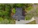 An aerial view of a home showcasing its well-maintained roof and landscaping surrounded by lush greenery and trees at 11165 Bentley Chase Dr, Johns Creek, GA 30097