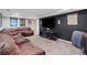 Finished basement with large brown sectional and mounted television at 11165 Bentley Chase Dr, Johns Creek, GA 30097
