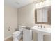 Powder room with granite sink, decorative mirror and a neutral color palette at 11165 Bentley Chase Dr, Johns Creek, GA 30097