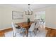 Light-filled dining room boasts a contemporary chandelier, stylish seating, and an open view to the living room at 11165 Bentley Chase Dr, Johns Creek, GA 30097