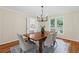 Bright dining room features hardwood floors, an elegant chandelier, and a view to the backyard at 11165 Bentley Chase Dr, Johns Creek, GA 30097