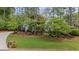 Beautiful home nestled among mature trees, showcasing a well-kept lawn and inviting curb appeal at 11165 Bentley Chase Dr, Johns Creek, GA 30097