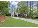 A side view of a white two-story home with black shutters and an expansive front lawn at 11165 Bentley Chase Dr, Johns Creek, GA 30097