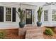 Inviting front entrance with a classic black door, decorative plants, and brick steps at 11165 Bentley Chase Dr, Johns Creek, GA 30097