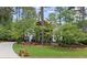 Charming home with well-manicured lawn, mature trees, and a neatly paved driveway at 11165 Bentley Chase Dr, Johns Creek, GA 30097