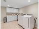 Bright laundry room features white cabinets, countertop and appliances at 11165 Bentley Chase Dr, Johns Creek, GA 30097