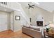 Bright open-plan living room with vaulted ceiling, fireplace, a staircase, and hardwood floors at 11165 Bentley Chase Dr, Johns Creek, GA 30097