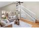 Bright open-plan living room with vaulted ceiling, fireplace, a staircase, and hardwood floors at 11165 Bentley Chase Dr, Johns Creek, GA 30097
