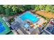 Aerial view of a large community pool with lounge chairs, umbrellas, and well maintained green spaces surrounding it at 11165 Bentley Chase Dr, Johns Creek, GA 30097