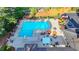 Aerial view showcasing a sparkling community swimming pool with ample seating and vibrant umbrellas around a well kept pool deck at 11165 Bentley Chase Dr, Johns Creek, GA 30097