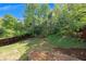Backyard view shows a slope, fencing, and trees at 213 Roseman Way, Woodstock, GA 30188