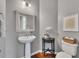 Charming powder room with pedestal sink, decorative mirror, and classic fixtures enhances the home at 213 Roseman Way, Woodstock, GA 30188