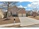 Two-story brick home with a two-car garage, featuring a long driveway and well-maintained lawn in the neighborhood at 213 Roseman Way, Woodstock, GA 30188