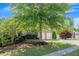 Two-story brick home with a two-car garage, featuring mature trees and landscaping in a serene setting at 213 Roseman Way, Woodstock, GA 30188