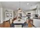 Kitchen features an island, stainless appliances, and dining area with stylish chandelier at 213 Roseman Way, Woodstock, GA 30188