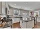 Open kitchen features white cabinets, granite countertops, stainless appliances, and an island with seating at 213 Roseman Way, Woodstock, GA 30188