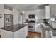 Well-equipped kitchen features granite countertops, stainless steel appliances, ample cabinetry, and a functional island at 213 Roseman Way, Woodstock, GA 30188