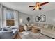 Cozy living room featuring a sectional sofa, natural light, and ceiling fan at 213 Roseman Way, Woodstock, GA 30188
