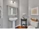 Charming powder room with pedestal sink, decorative mirror, and stylish fixtures at 213 Roseman Way, Woodstock, GA 30188