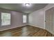 A simply designed bedroom with wood-look flooring, two windows, and a 6-panel door to a closet at 350 White Birch Dr, Covington, GA 30016