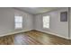 Bedroom featuring modern gray walls, two windows, and attractive wood-look flooring at 350 White Birch Dr, Covington, GA 30016
