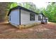 Side view of single story home with light siding and dark trim, nestled among lush trees at 350 White Birch Dr, Covington, GA 30016