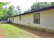 Side view of home with white siding, black trim, and low garden at 350 White Birch Dr, Covington, GA 30016
