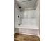 Modern shower and tub combo featuring white fixtures, a black shower head, and wood-look floors at 350 White Birch Dr, Covington, GA 30016