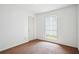 Neutral-colored walls and flooring in an empty bedroom with white trim around a window at 2962 Invermere Woods Ct, Lithonia, GA 30038