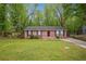 Single-story brick home featuring a well-maintained lawn and mature trees at 2962 Invermere Woods Ct, Lithonia, GA 30038
