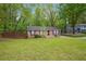 Well-maintained single-story brick home featuring a large grassy front yard at 2962 Invermere Woods Ct, Lithonia, GA 30038