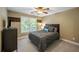 This bedroom features soft carpet, a modern ceiling fan, and a queen bed with an upholstered headboard at 4350 Oakdale Vinings Se Cir, Smyrna, GA 30080
