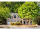 Charming brick home with lush landscaping, mature trees, and a cozy front porch at 4350 Oakdale Vinings Se Cir, Smyrna, GA 30080