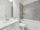 Well-lit bathroom with marble countertop, framed mirror, and tiled shower and bathtub surround at 4775 Columbia St, Cumming, GA 30040