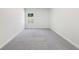 Bright bedroom featuring neutral walls and soft carpet flooring with one window view at 4775 Columbia St, Cumming, GA 30040