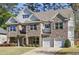 Beautiful two-story home showcasing a brick and stone exterior, a manicured lawn, and a convenient two-car garage at 4775 Columbia St, Cumming, GA 30040