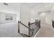 Bright hallway features neutral walls and carpet flooring with wrought iron railing and a window view at 4775 Columbia St, Cumming, GA 30040
