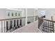 Upper hallway features neutral walls, carpet flooring, and wrought iron railing with window views at 4775 Columbia St, Cumming, GA 30040